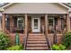 Inviting covered front porch with seating, decorative columns, and a welcoming entryway at 4010 Hamilton Mill Rd, Buford, GA 30519