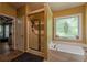 This bathroom boasts a shower and garden tub with decorative window and fixtures at 5342 Lakerock Sw Dr, Atlanta, GA 30331
