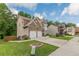 Exterior view of a home with a two-car garage, manicured lawn and mature trees at 5342 Lakerock Sw Dr, Atlanta, GA 30331