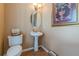 Cozy powder room featuring a pedestal sink, decorative mirror, and neutral wall color at 5342 Lakerock Sw Dr, Atlanta, GA 30331