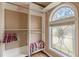 Open walk-in closet with custom shelving and decorative window at 5342 Lakerock Sw Dr, Atlanta, GA 30331