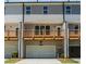 View of multi-story townhome featuring a wooden deck above the garage with neutral paint colors and a well-lit entry at 1240 Ainsworth Aly # 39, Sugar Hill, GA 30518