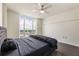 This bedroom features a large window, dark hardwood floors, and a stylish gray tufted headboard at 3475 Oak Valley Rd # 1850, Atlanta, GA 30326