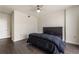 Bedroom showcasing a stylish gray tufted headboard, dark hardwood floors, and a white door at 3475 Oak Valley Rd # 1850, Atlanta, GA 30326