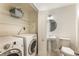 This laundry room includes a washing machine, dryer, pedestal sink, toilet, and storage shelves at 3475 Oak Valley Rd # 1850, Atlanta, GA 30326
