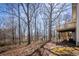 Backyard showcasing the home's wooden deck, surrounded by a natural landscape with trees at 2192 Stenger Rd, Douglasville, GA 30135