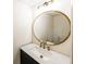 Stylish powder room featuring a marble countertop, modern fixture, and round mirror at 2192 Stenger Rd, Douglasville, GA 30135