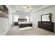 Bedroom with tray ceiling, neutral carpet, and a matching dresser with mirror at 3442 Old Towne Ln, Cumming, GA 30040