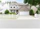 Charming two-story home features a well-manicured lawn, white picket fence, and attached two-car garage at 3442 Old Towne Ln, Cumming, GA 30040