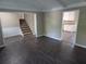 Open-concept living room with updated flooring and a view of the staircase and kitchen at 4015 Woodland Nw Dr, Kennesaw, GA 30152