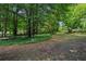 Large backyard with mature trees, lush greenery, and ample space for outdoor activities at 4192 Alaina Cir, Austell, GA 30106