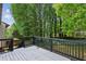 Wooden deck overlooking the backyard with wooded scenery and a privacy fence at 4192 Alaina Cir, Austell, GA 30106