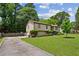 A well-maintained home featuring a long driveway, lush lawn, and thoughtfully placed shrubbery at 4192 Alaina Cir, Austell, GA 30106