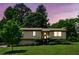 Inviting home at dusk, surrounded by lush greenery and a well-kept lawn, enhanced by exterior lighting at 4192 Alaina Cir, Austell, GA 30106