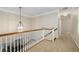 Upper hallway featuring wood railing and a modern chandelier at 626 Kimberly Ne Ln, Atlanta, GA 30306