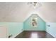 Finished attic featuring vaulted ceiling, window, light teal walls and wood-look floor at 1625 Alcovy River Dr, Dacula, GA 30019