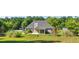 Expansive backyard featuring a covered patio, lush lawn, a fire pit, and a charming play structure at 1625 Alcovy River Dr, Dacula, GA 30019
