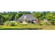 Spacious backyard features a covered patio, fire pit, and a charming wooden playset, perfect for outdoor enjoyment at 1625 Alcovy River Dr, Dacula, GA 30019