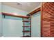 Custom closet featuring wood shelving and wooden rods against a light teal painted wall at 1625 Alcovy River Dr, Dacula, GA 30019