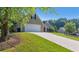 Spacious driveway leading to an attached garage, surrounded by green landscaping and mature trees at 1625 Alcovy River Dr, Dacula, GA 30019