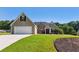 Well-manicured lawn and attached garage complement this traditional home at 1625 Alcovy River Dr, Dacula, GA 30019