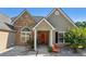 Charming home featuring stone accents, a cozy porch, and a vibrant red front door at 1625 Alcovy River Dr, Dacula, GA 30019