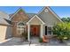 Charming home featuring a stone facade and a welcoming front porch with a vibrant red front door at 1625 Alcovy River Dr, Dacula, GA 30019