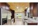 Updated kitchen featuring stainless steel appliances, granite countertops, and wood-paneled ceiling at 1625 Alcovy River Dr, Dacula, GA 30019