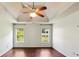 Spacious main bedroom featuring a tray ceiling, ceiling fan and gleaming hardwood floors at 1625 Alcovy River Dr, Dacula, GA 30019