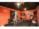 Home gym with black rubber flooring, vivid orange walls, and full set of exercise equipment at 190 Country Club Dr, Hiram, GA 30141