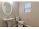 Cozy half bathroom with a sleek pedestal sink and a well lit window at 1720 New Orleans Way, Mcdonough, GA 30252