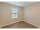 The bedroom has wood-look flooring and natural light from the window at 1720 New Orleans Way, Mcdonough, GA 30252
