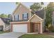 Two-story home featuring a brick-and-vinyl facade with an attached garage and a well-manicured front lawn at 1720 New Orleans Way, Mcdonough, GA 30252