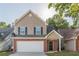 Two-story home featuring a brick-and-vinyl facade with an attached garage and a well-manicured front lawn at 1720 New Orleans Way, Mcdonough, GA 30252
