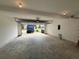 Spacious two car garage featuring a light-colored concrete floor and a view of the neighborhood through the open door at 1720 New Orleans Way, Mcdonough, GA 30252