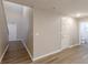 Hallway with wood-look flooring, neutral paint, and multiple doors, with staircase leading to upper level at 1720 New Orleans Way, Mcdonough, GA 30252
