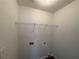 A compact laundry area equipped with a wire shelf for storage and conveniently placed electrical and plumbing connections at 1720 New Orleans Way, Mcdonough, GA 30252