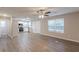 Open-concept living room with wood-look floors, neutral paint, ceiling fan, and bright windows at 1720 New Orleans Way, Mcdonough, GA 30252