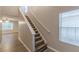 Carpeted staircase with white trim, leading to the upper level, adjacent to the main entrance at 1720 New Orleans Way, Mcdonough, GA 30252