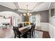 Bright dining room featuring a modern chandelier, coffered ceiling, and large window with decorative curtains at 2109 Cape Ivey Ct, Dacula, GA 30019