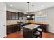 Modern kitchen has stainless steel appliances, granite counters, dark wood cabinets, and a center island at 2109 Cape Ivey Ct, Dacula, GA 30019