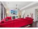 Bright living room features a cozy fireplace, ceiling fan, and large red sofa for comfortable gathering at 2109 Cape Ivey Ct, Dacula, GA 30019