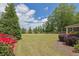 Landscaped backyard with a well-maintained lawn, colorful flowers, and lush greenery at 2205 Beaver Shop Ne Rd, Marietta, GA 30066
