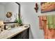 Bathroom boasts granite counters, a decorative mirror, sconces, and neutral toned towels at 2205 Beaver Shop Ne Rd, Marietta, GA 30066