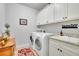 Bright laundry room features white cabinets, granite counters, and modern washer and dryer at 2205 Beaver Shop Ne Rd, Marietta, GA 30066
