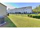 Townhome backyard featuring a well-maintained lawn, fenced boundary, and adjacent building views at 2326 Nicole Dr, Hampton, GA 30228