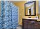 Bathroom featuring a shower/tub combo with a seashell shower curtain and a dark vanity at 2326 Nicole Dr, Hampton, GA 30228
