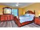 Bedroom featuring hardwood floors, a ceiling fan, and an ornate wood bed frame with matching dresser at 2326 Nicole Dr, Hampton, GA 30228