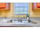 Close up of kitchen sink under window, with granite countertops and stainless steel fixtures at 2326 Nicole Dr, Hampton, GA 30228