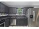 Modern kitchen with black cabinets, stainless steel appliances, and a stylish backsplash at 430 Pilgrim Ln, Powder Springs, GA 30127